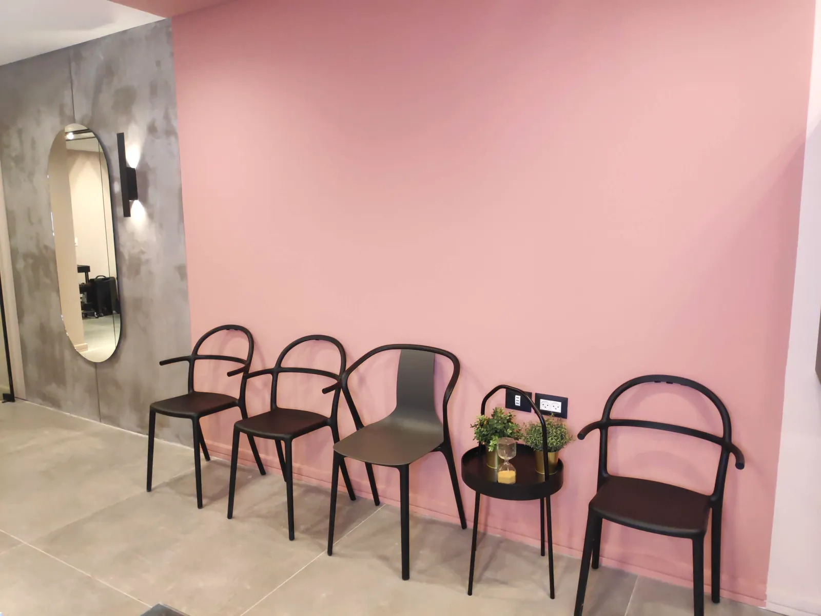 The waiting area with chairs against the pink wall